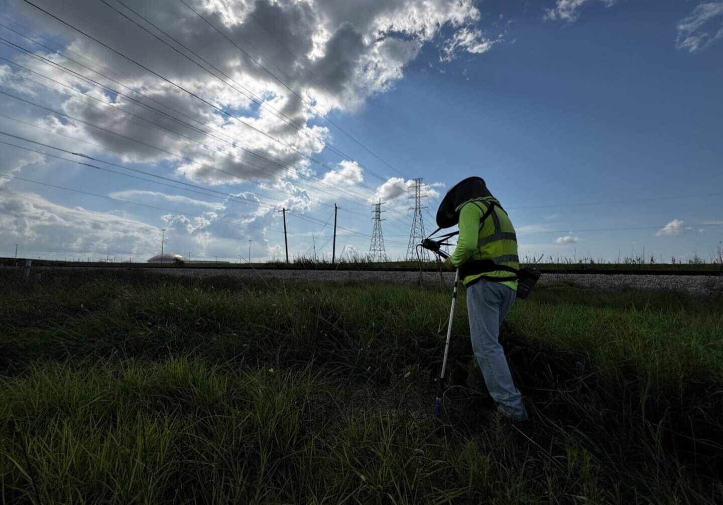 Surveyor using tripod near transmission towers