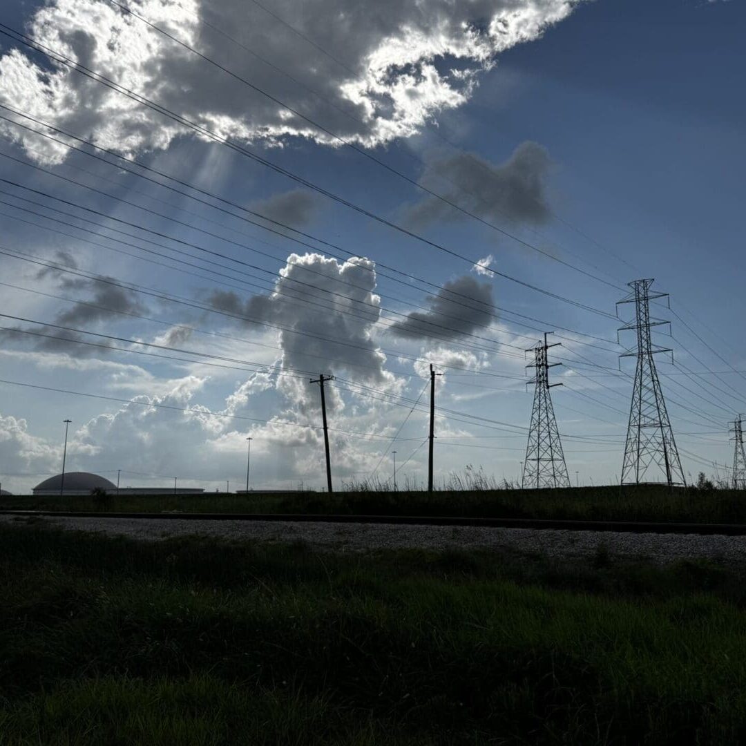 Power transmission towers beneath dramatic sunbeams