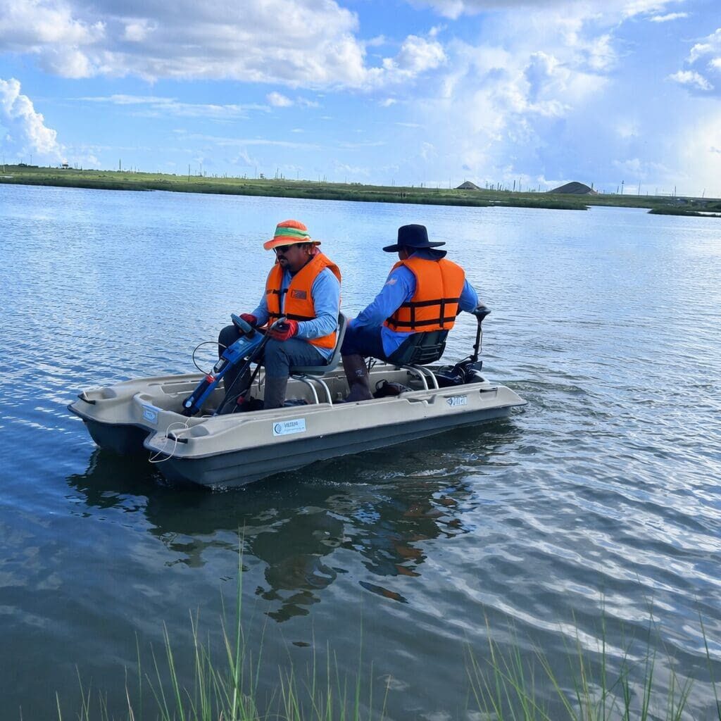 Two people boating on calm marsh waters