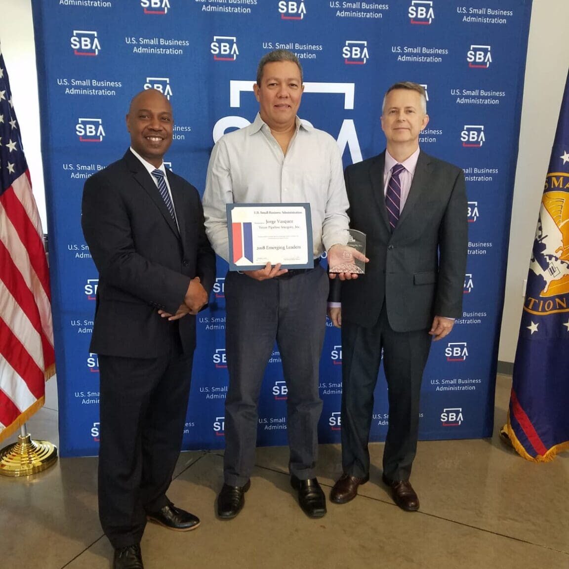 Three men holding certificate at SBA backdrop