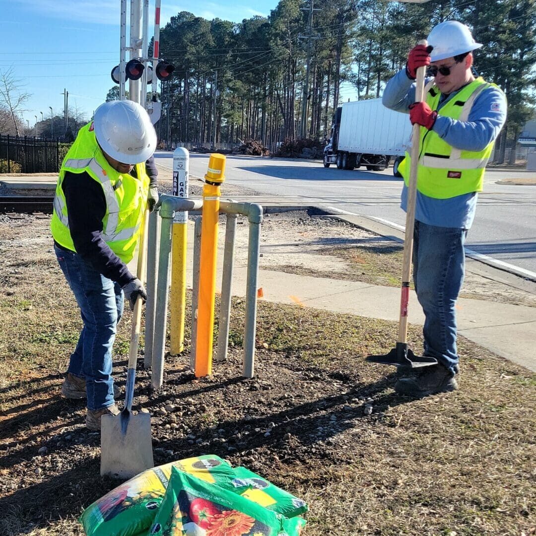 Two utility workers digging near roadside